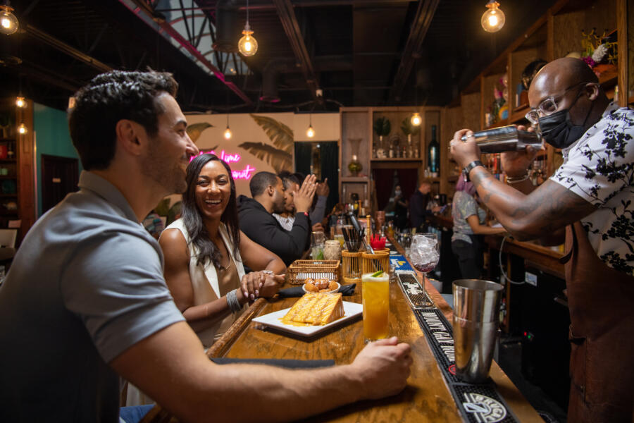 Friends enjoy cocktails at the bar of 14 Parish